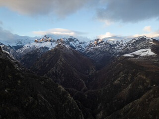 Winter landscape in Bulgaria, Balkan Mountains, with snow-covered hills and scattered pine trees under a blue sky. Peaceful rural scenery, natural wilderness, cold season, wide panoramic view