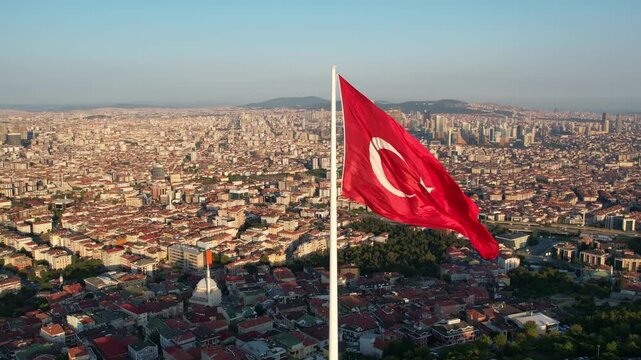 Drone footage showing the large Turkish flag, green park areas and Camlica Tower on Camlica Hill under clear daylight.