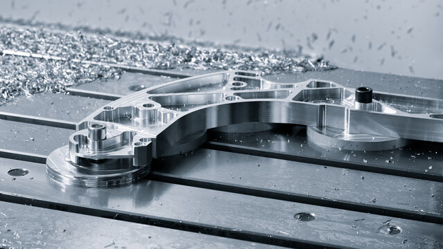 Complex metal work on machine table, made on modern programmable CNC multifunctional metalworking machine, industrial concept background