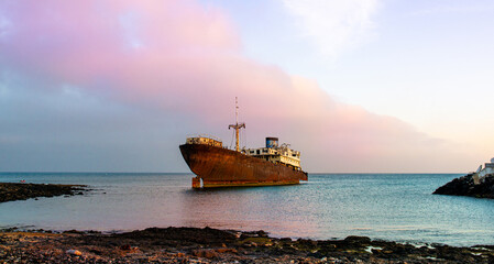 Fototapeta premium Rusty Abandoned Ship Sitting By The Seashore