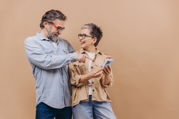Senior couple sharing a happy moment using smartphone
