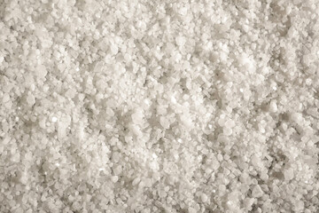 White natural salt as background, closeup view