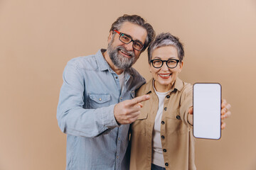 Senior couple pointing at smartphone blank screen