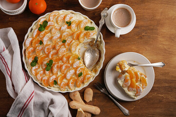 Bowl of mandarin tiramisu on the wooden table with hot chocolate, top view