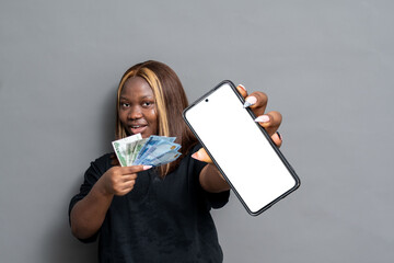 nigerian lady holding money and showing her phone screen