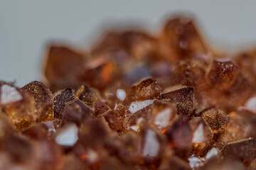 Citrinkristalle in verschiedenen Rottönen liegen auf einer Fläche und reflektieren das Licht aus...