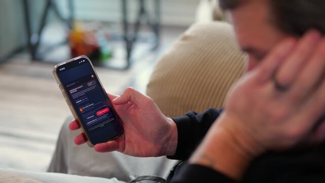 Middle Aged Man Gets Mobile Phone Notification of Suspicious Foreign Banking Transactions - FinTech Cybersecurity Mobile Banking Alerts Concept
