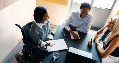 Diverse professionals having a meeting around a table with a laptop