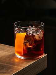 Negroni cocktail with orange peel on wooden surface