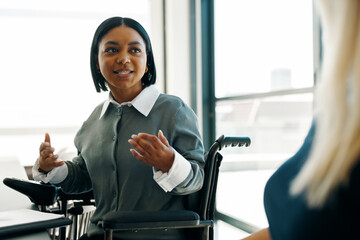 Professional woman in wheelchair discussing ideas in a modern office environment
