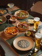 A gourmet banquet of Chinese cuisine features various meat and fish dishes served alongside fresh vegetable appetizers on a restaurant table for a delicious dinner meal