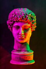 Classical Hermes Sculpture Bust Illuminated with Vibrant Neon Pink Orange Green Gradient Lighting