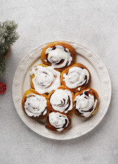 Christmas tree shape glazing cinnamon rolls or cinnabon buns on white plate. Top view.