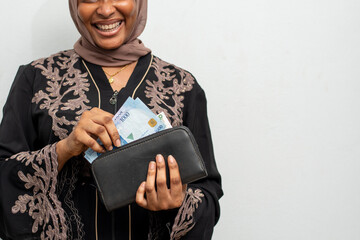 young black woman putting money in her her purse