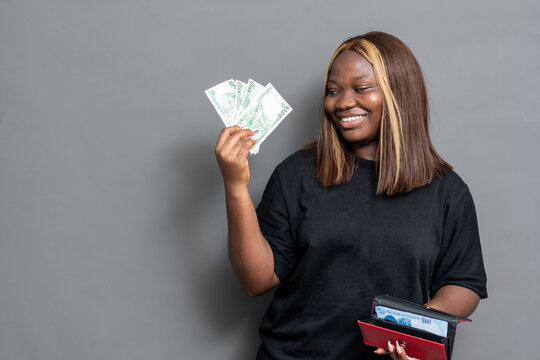 Happy NIgerian woman flaunting some cash from her purse