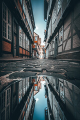 Low Angle View of Historic Half-Timbered Alley in Celle with Street Reflection, Moody Daylight