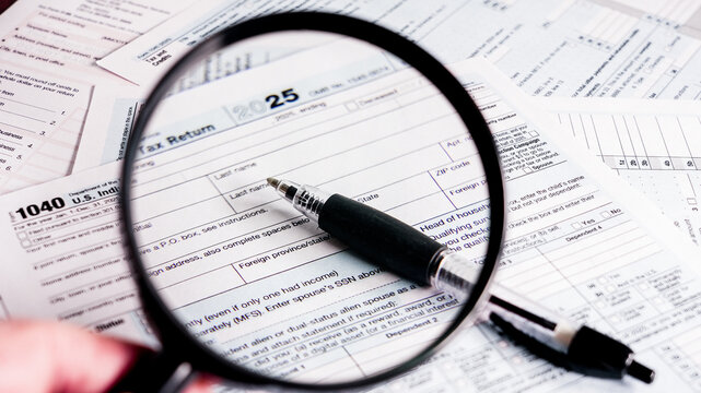 Detailed view of tax forms and a pen on a workspace during tax season in the United States