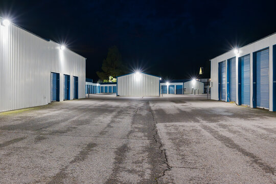 Evening view of a large illuminated self storage facility offering individual units for rent.