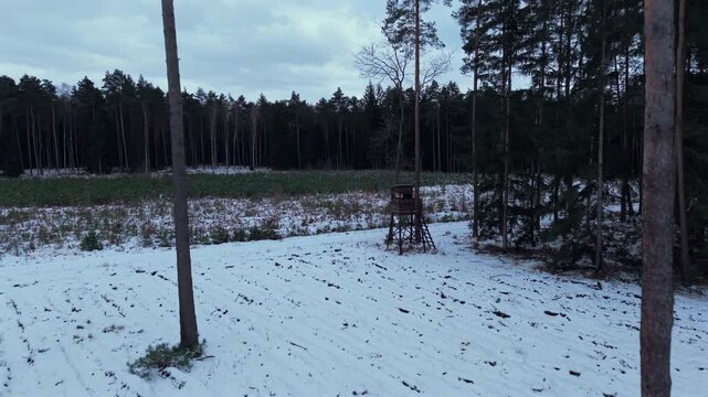 Tower used by hunters to wait and lure for animals to shoot. In the edge of the forest in winter time
