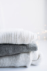 White and gray sweaters with bokeh lights and space for text.