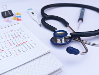 medical scheduling and healthcare calendar planning concept with stethoscope, syringe, calendar, and office supplies