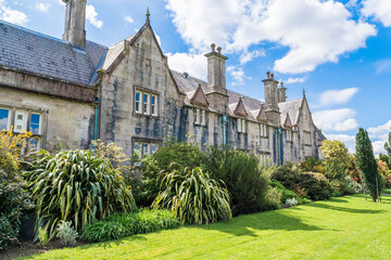 Architectural detail of a historic stone building featuring multiple slate-tiled dormer windows and...