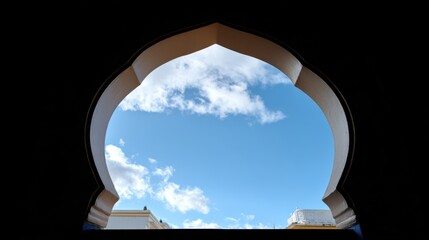 Moroccan archway framing blue sky with clouds