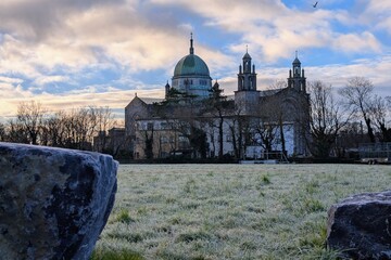 Galway Cathedral Irish Landmark Architecture with Green Dome and Stone Towers Under Blue Sky and Frosty Morning Grass in Ireland