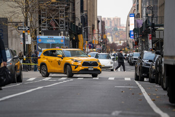 New York, USA - November 23, 2025: Classic yellow cab taxis move through the streets of New York City by day, capturing the iconic rhythm, energy, and everyday life of the metropolis.