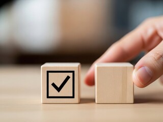 Hand reaching towards wooden blocks one with a checkmark symbol visible