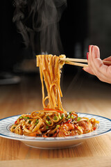 Delicious noodles being lifted with chopsticks, showcasing a flavorful dish from Asian cuisine ideal for food lovers and culinary enthusiasts