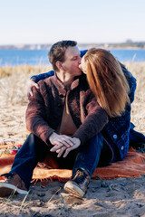 Portrait happy beautiful couple in love enjoying autumn picnic in autumn park. Vertical photo. High quality photo