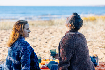 Portrait happy beautiful couple in love enjoying autumn picnic in autumn park. Back view. High quality photo