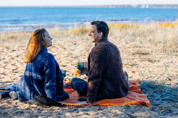 Portrait happy beautiful couple in love enjoying autumn picnic in autumn park. Back view. High quality photo