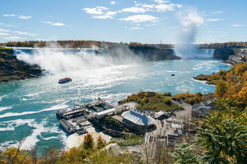 Niagara Falls American Falls and Horseshoe Falls in a sunny day in autumn foliage season. Niagara City Cruise Boat Tour.