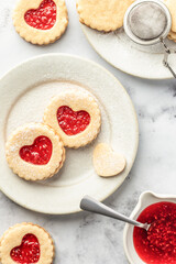 Linzer cookies in shape of heart with jam on white marble background. Mother's day, Valentine's day. Homemade present