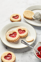 Linzer cookies in shape of heart with jam on white marble background. Mother's day, Valentine's day. Homemade present