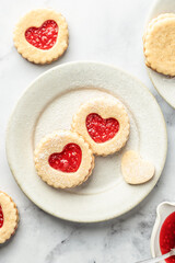 Linzer cookies in shape of heart with jam on white marble background. Mother's day, Valentine's day. Homemade present