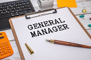 GENERAL MANAGER text on a notebook with pen, folder on a chart background.