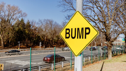 Yellow square BUMP road sign at the side of the road