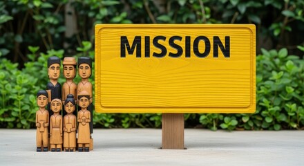 Wooden carved figures stand beside a bright yellow mission sign with clear black text in an outdoor setting