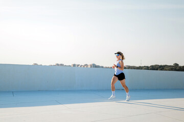 Woman runs on a rooftop in a city setting