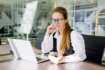 Businesswoman working at a laptop in an office setting