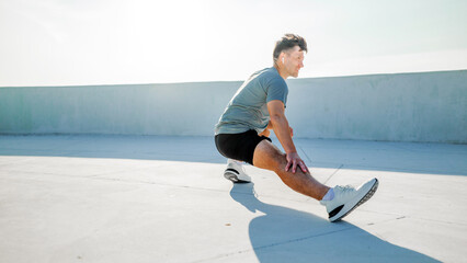 Man stretching on a rooftop in the morning