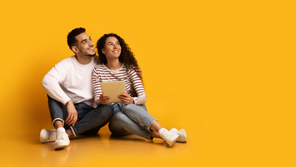 Online Offer. Young Middle Eastern Couple Sitting With Digital Tablet And Looking Away With...