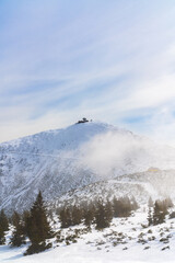 Obraz premium Highest mountain is Snezhka, snowy mountain landscape in winter in Poland. Winter nature, travel destination, and outdoor scenery concept.