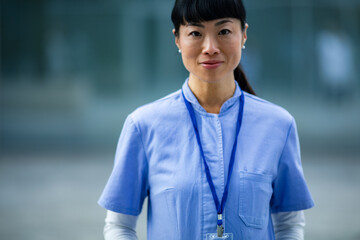 Adult female nurse with calm expression outside hospital