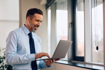 Fototapeta premium Happy businessman working on laptop in office.