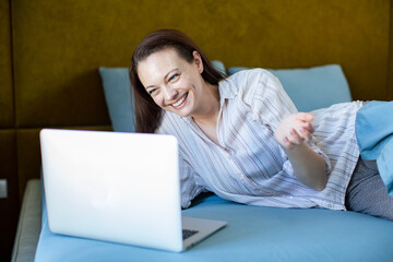 Adult woman smiling on video call with laptop at home