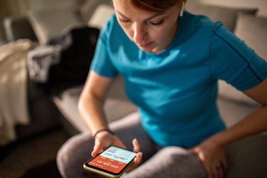 Adult woman focused on fitness app at home